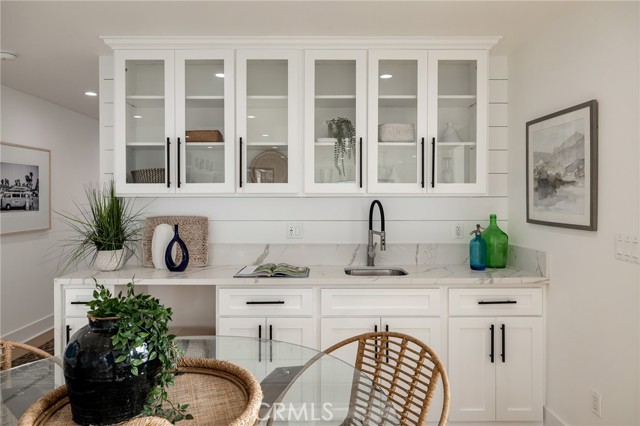 Second Level Service Bar with Water Fall Quartz Counters and Glass Display Cabinetry.