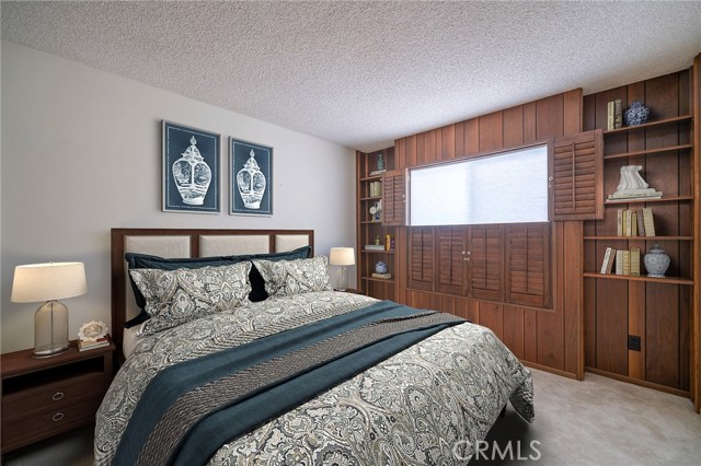 Bedroom 1 with beautiful built-in shelving and shutters.