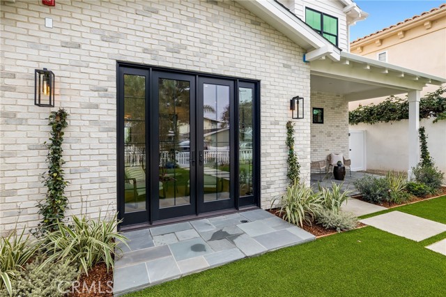 Paneled glass doors allow family and neighborly gatherings to flow into the front yard