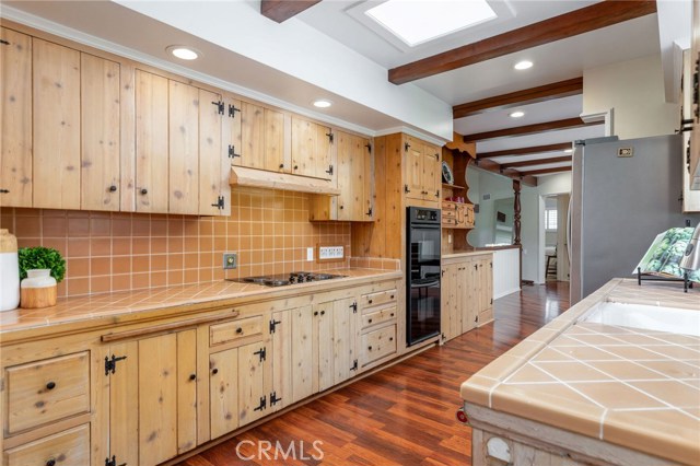 The spacious galley style kitchen has solid wood cabinetry and classic tile work - embrace the timeless style or customize to you own design.