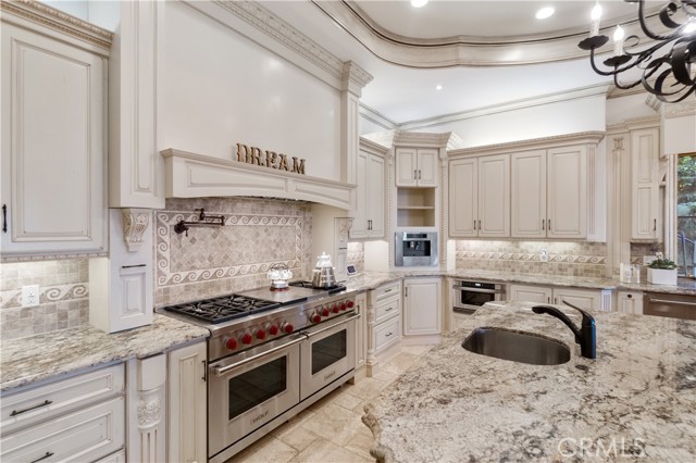 Kitchen with Stainless Steel Wolf Stove Appliance. Extra Sink on center island for easy access and cooking.