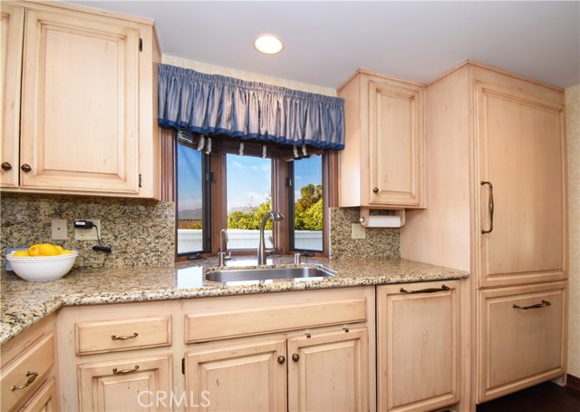 Remodeled kitchen with custom cabinetry and granite counters.