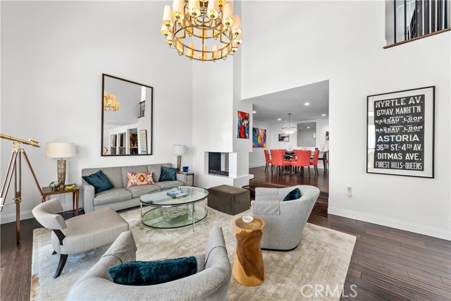 Living room with soaring ceilings and huge formal dining room beyond! Double sided fireplace, too!