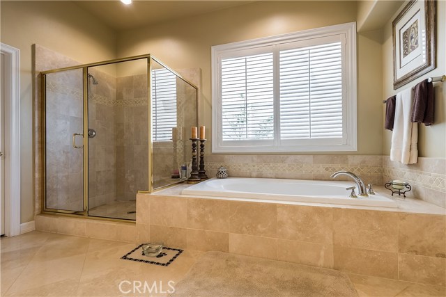 Master bath with travertine flooring, separate shower and tub.  Plantation shutters