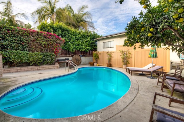 Backyard sparkling pool with a view of the back house and detached garage.