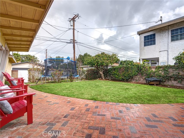 The large back yard is dotted with numerous trees including lemon, lime, pomegranate, and fig trees!