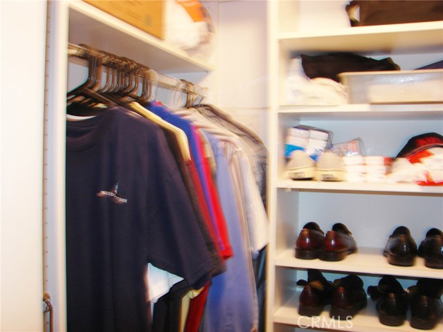 ONE SECTION OF THE MASTER WALK-IN CLOSET.