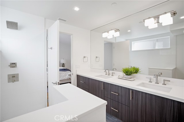 Master bath with floating cabinets, quartz countertop, counter-to-ceiling mirror