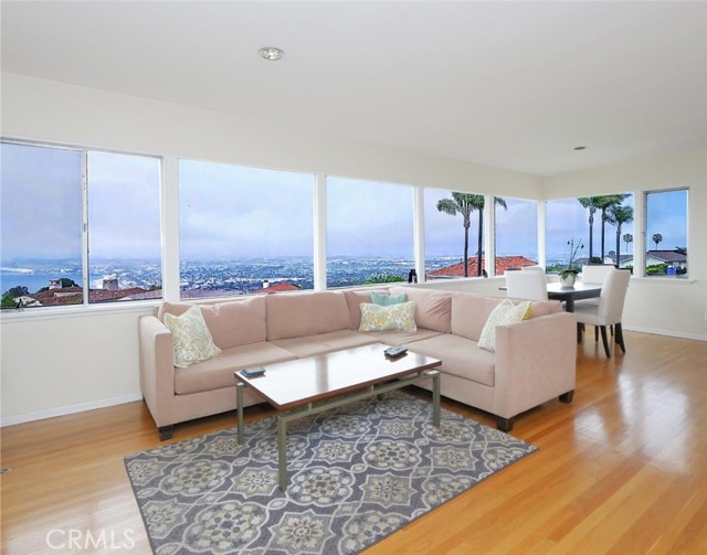 Spacious living room with walls of glass to the  panoramic Queen's necklace views