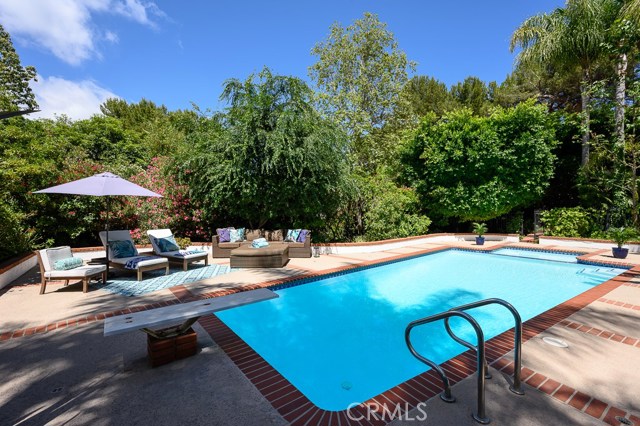 Refreshing pool surrounded by lush greenery with lots of deck space to relax poolside.