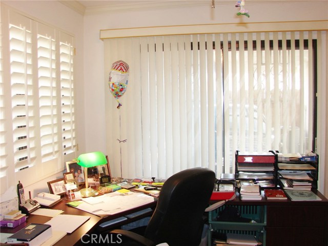 ANOTHER VIEW INSIDE THE DEN/STUDY. PLANTATION SHUTTERS AND WOOD LAM. FLOORING.