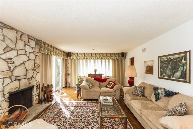 Lovely Living Room with PV Stone fireplace, looking towards the Formal Dining Area.