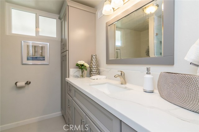 The fully remodeled 2nd bathroom features new tile flooring and a newly tiled shower. Large vanity with linen closet. The toilet is new, too.