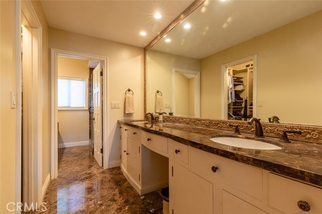 Master bath  Contains marble counter-tops.  Entrance to walk-in closet is to the left and custom cabinets.