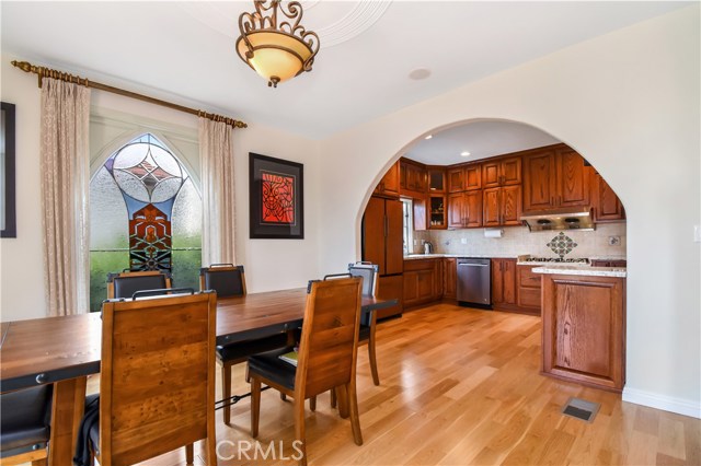 Dining room open to kitchen with beautifully stained glass for accent.