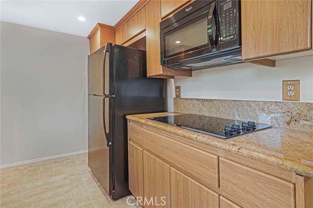 Side of Kitchen with the Stove, Ovens are on the other side of the Refrigerator, Sink is across, overlooks Patio.
