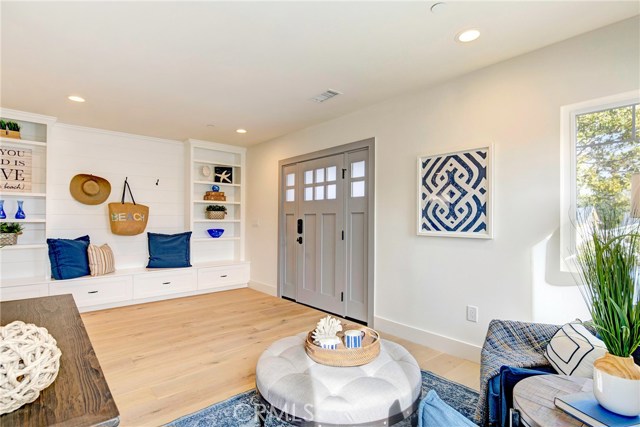 Entry way with sitting area, cubbies, shelves, storage doors, and coat hooks.  Beautiful French Oak flooring throughout.