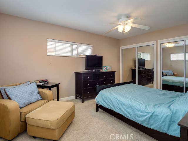 Spacious master bedroom with mirrored wardrobe closet and plenty of room for seating.