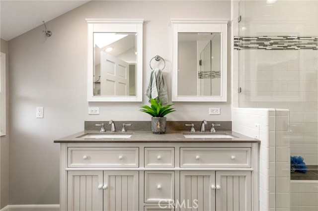 The primary suite's bathroom is newly remodeled in a gorgeous contemporary style with neutral tones and efficient use of space.