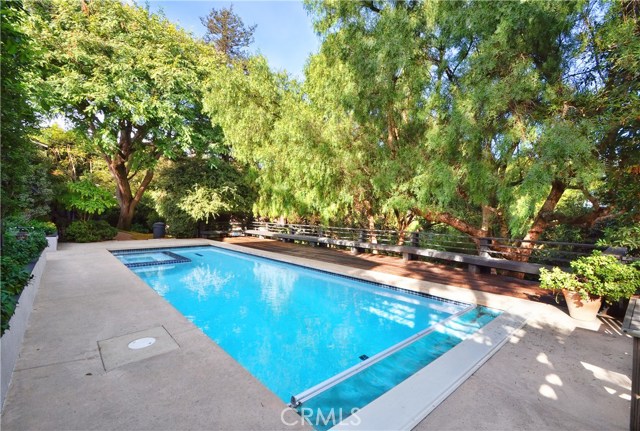 Wood deck next to pool with bench seating/fence with pool cover