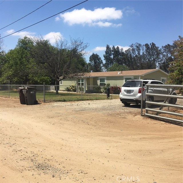 Large driveway with fenced yard.