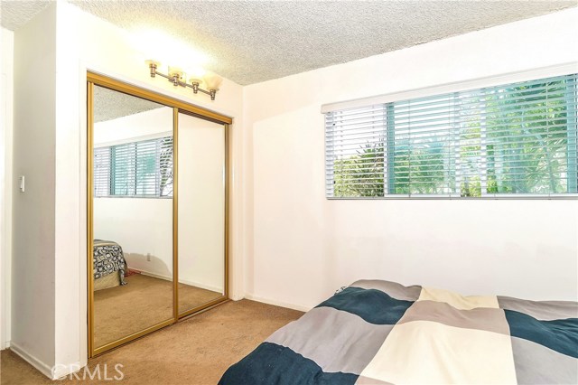 The guest bedroom has an ample closet and a large window that looks out onto the rear yard and lets in the ocean breeze