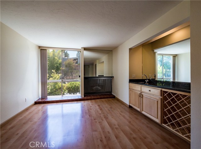 Laminate wood floors, floor to ceiling windows, gas fireplace, smooth ceilings, ceiling fan, granite counter at the remodeled wet bar with wine rack.