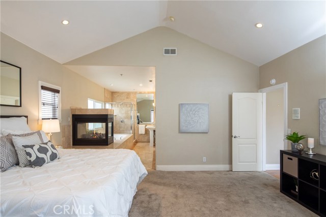 The exquisite master suite located on the upper level is a spacious room with many features including high vaulted ceilings, elegant gas fireplace, access to the deck and rooftop deck, and en-suite bathroom.