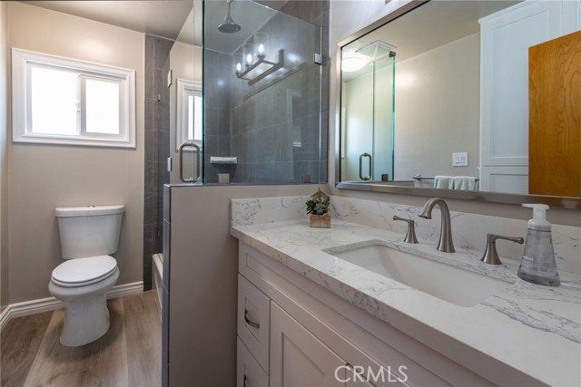 CENTRAL/BACK BATHROOM - NEW 42" CABINET QUARTZ COUNTER TOP, FINE ITALIAN PORCELAIN TILE, BEAUTIFUL 1/2" FRAME-LESS SHOWER ENCLOSURE, NEW VINYL FLOORS