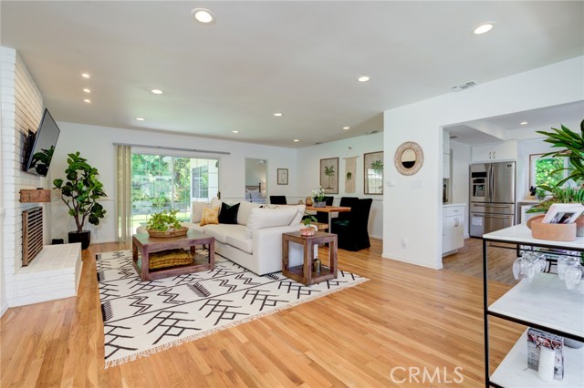 Large living/dining area with wood floors and recessed lighting