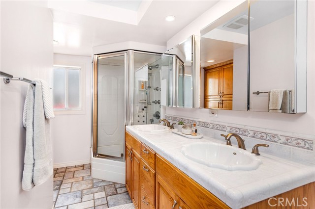 Bathroom by Main Bedroom has dual sink and a specialized shower -tub