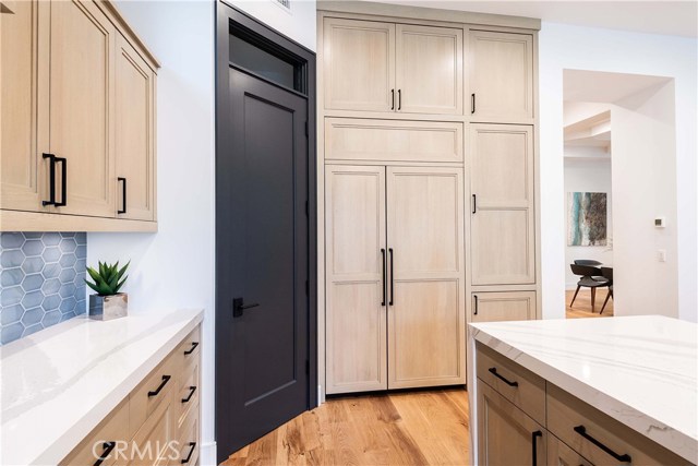 Jenn-Air built in refrigerator with Custom wood panels provide a clean look. The oversize shelves in the pantry accommodate larger boxes and appliances.