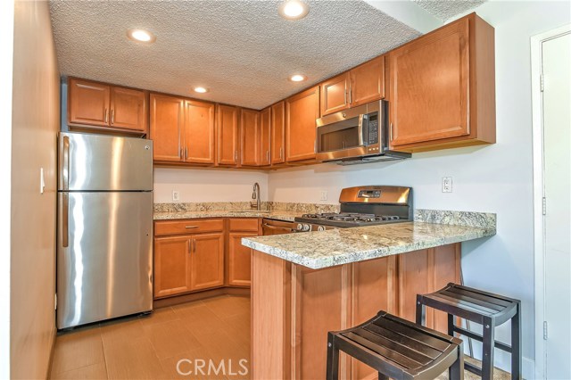 The guest kitchen has  granite counters, bar counter, abundant cabinets and stainless steel appliances