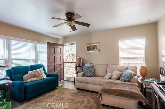 Sunny living room in front unit (555). Laminate floors, ceiling fan and upgraded windows make this a very nice room.