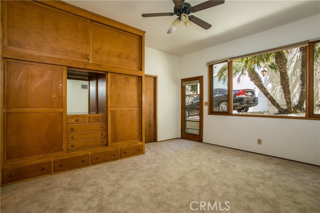 The master bedroom has a large window, built in vintage storage cabinets and a full bathroom.