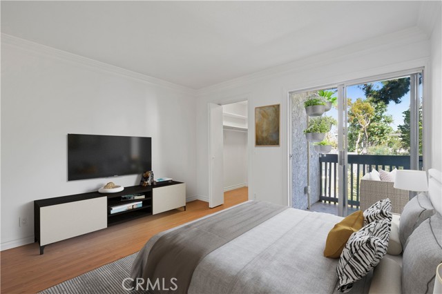 Bedroom with walk-in closet and access to balcony, virtually staged.