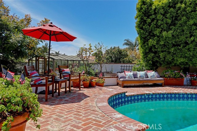 in ground pool with surrounding brick backyard