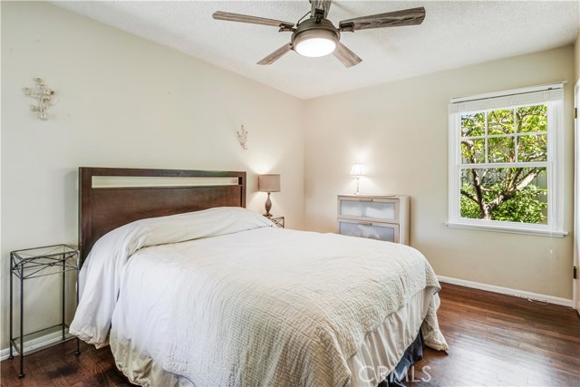 Master bedroom with hardwood flooring and natural light streaming in