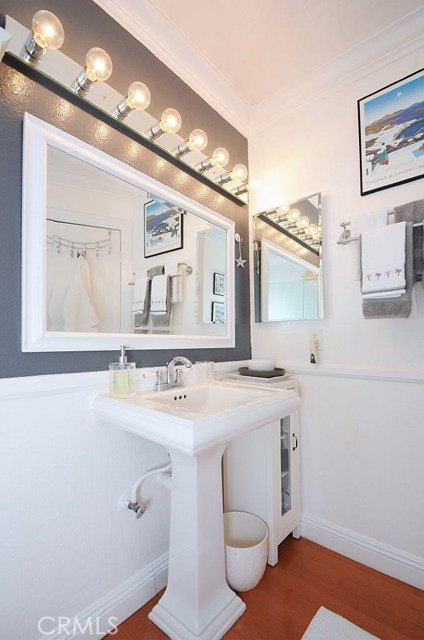 Remodeled Bathroom with Laminate Wood Flooring and Pedestal Sink