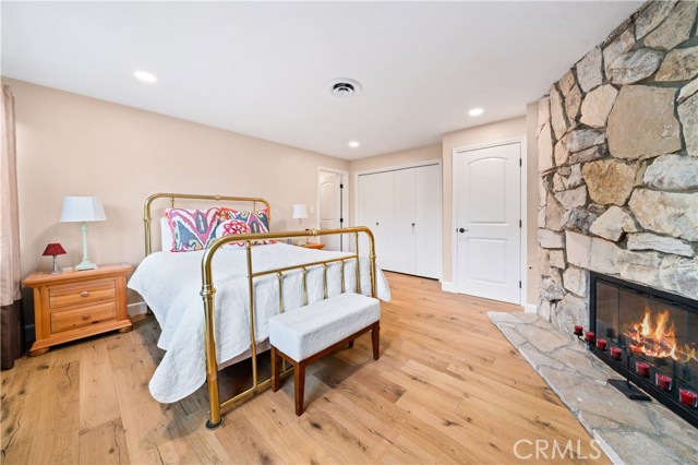 Downstairs bedroom with custom PV stone wood burning fireplace and two closets one of which is a walk-in.