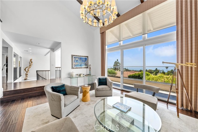 View of living room with spiral stairway beyond that leads to the home's entry level.