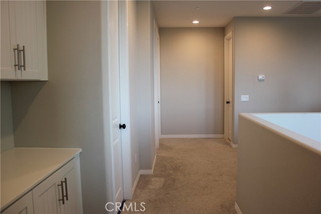 Spacious hallway with canned recessed lighting.