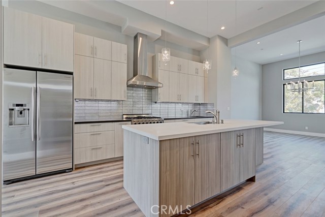 THE KITCHEN HAS DOUBLE SINKS AND LOTS OF COUNTER SPACE FOR COOKING. STAINLESS STEEL SIX BURNER STOVE AND DOUBLE DOOR REFRIGERATOR