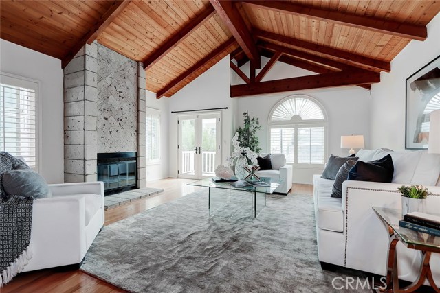 spacious wood beam vaulted ceiling in main living area with fireplace