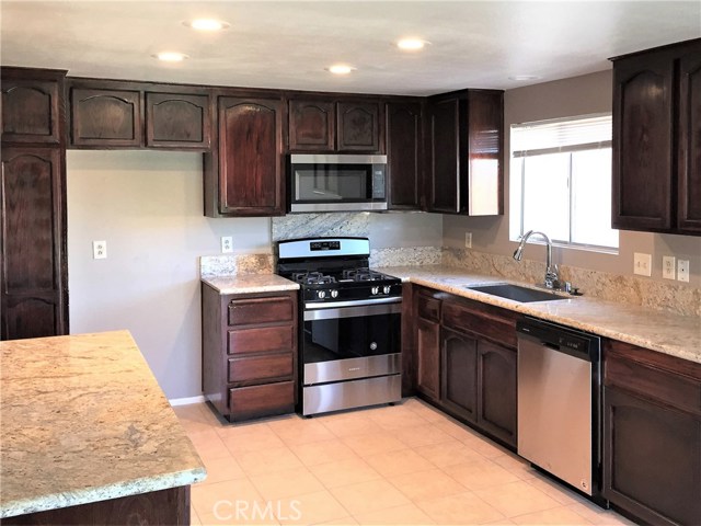 The updated kitchen features all new appliances, stunning stone counter tops, recessed lighting and a tile floor.