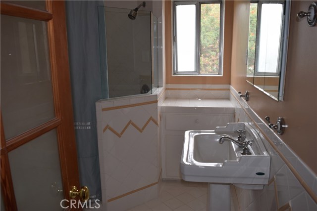 Charming secondary bath with built-in storage under the window.