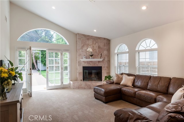 Family Room has vaulted ceilings, big skylight and floor to ceiling marble faced fireplace + French doors that open to backyard.