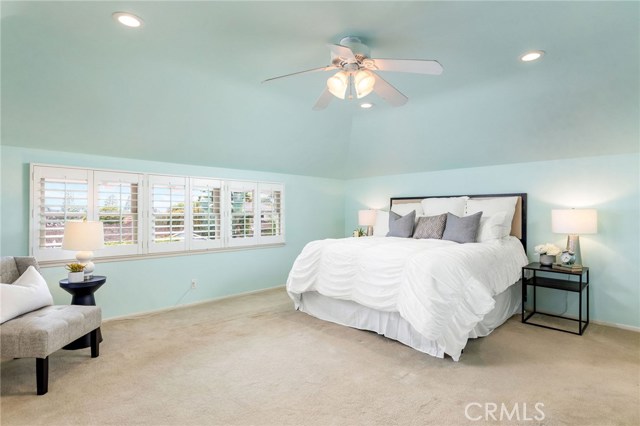 The peaceful primary bedroom suite brings ocean views and is a spacious retreat with built in storage, sitting bench, and an elegant and chic remodeled primary suite's bathroom.