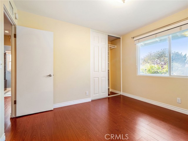 Bedroom #2 with hardwood floors and custom closet built ins.