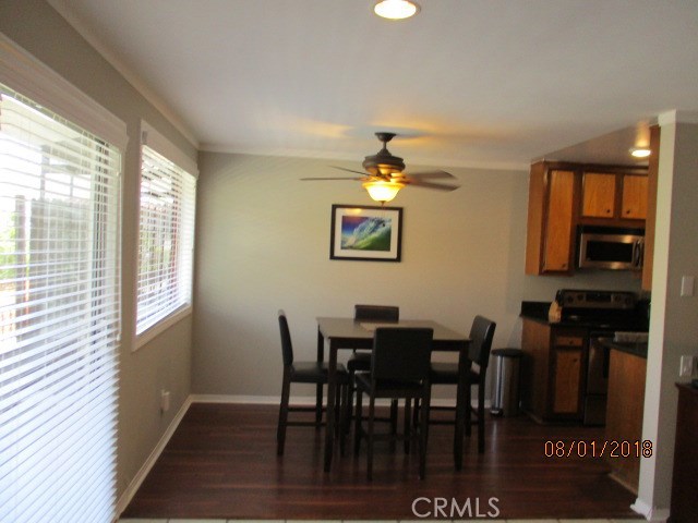 Dining area with ceiling fan and garden window and balcony sliding door.